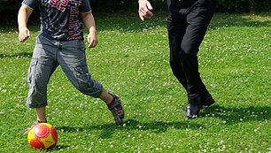 die Beine zweier Jungs die Ball spielen