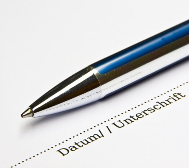 Kugelschreiber liegt auf einem Dokument mit den Zeilen "Datum/Unterschrift"