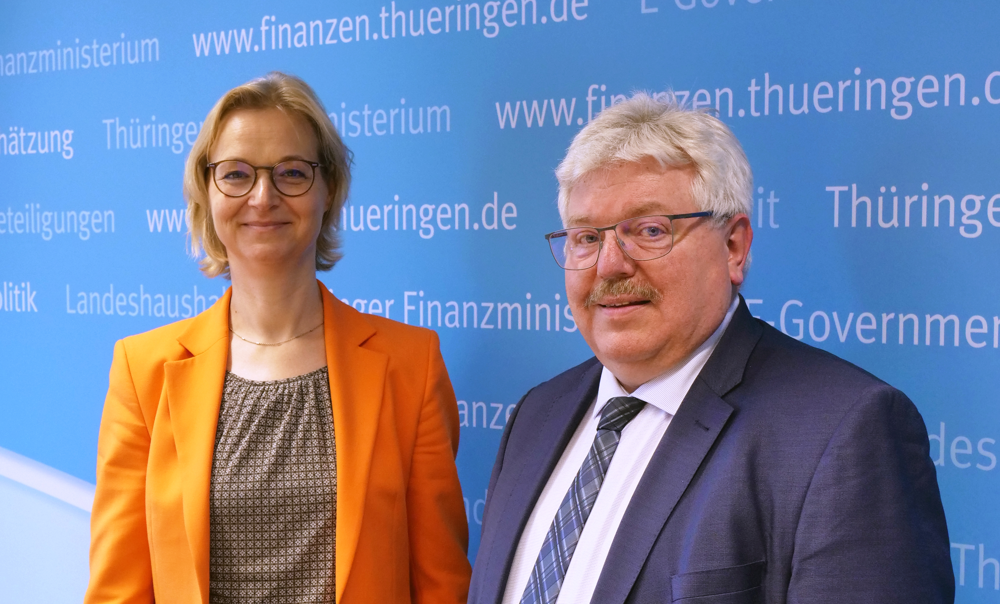 Wolf und Herzberg stehend vor blauer Wand